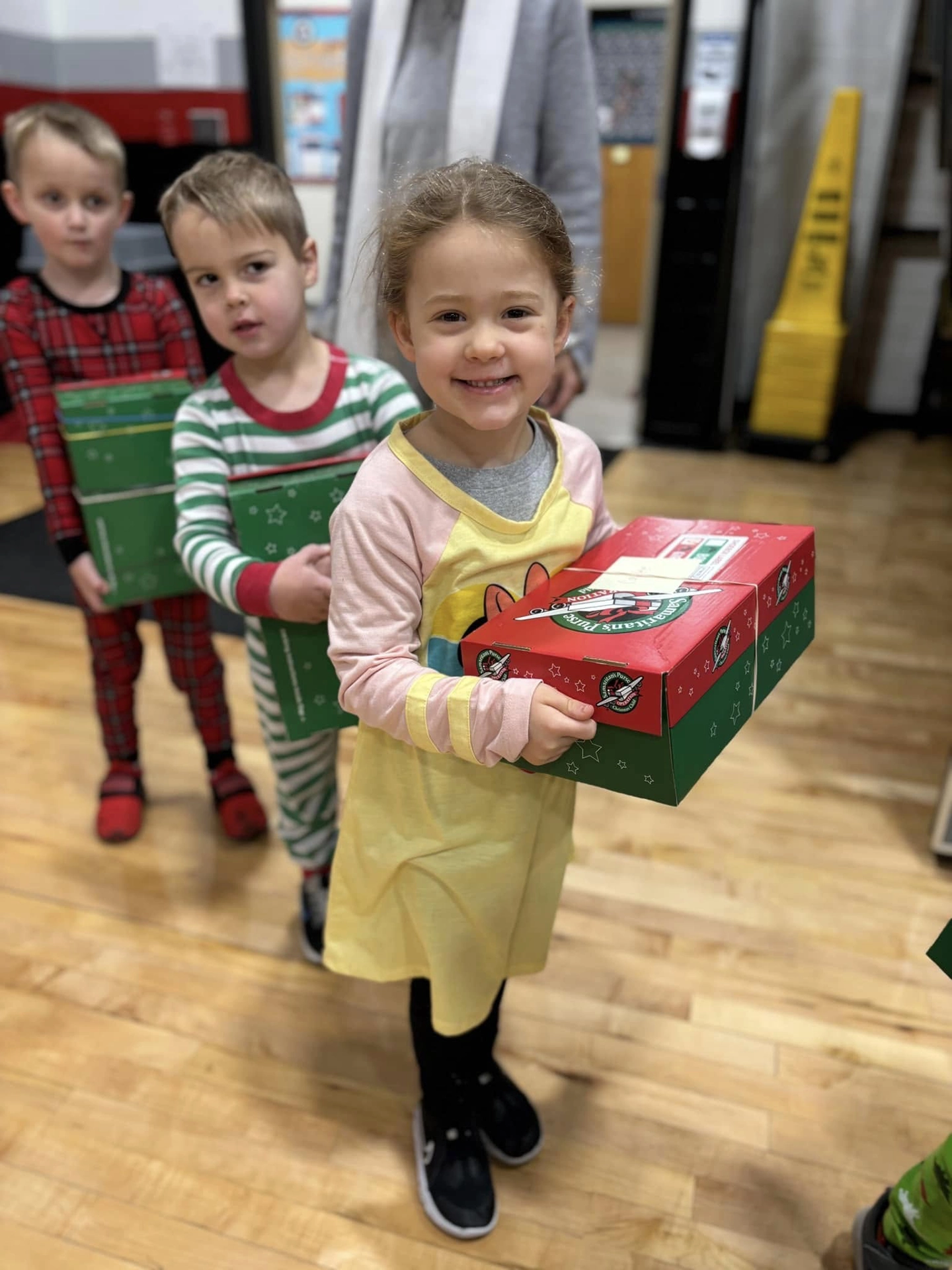 Pre-K students carry boxes